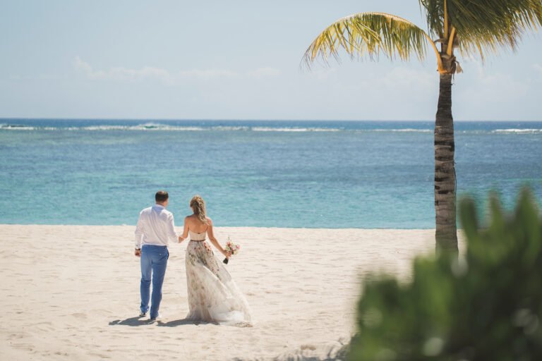 bride and groom are heading towards the ocean
